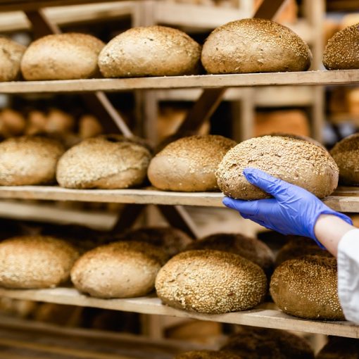 Kuvituskuva, leipuri ottaa leivän leipähyllyltä